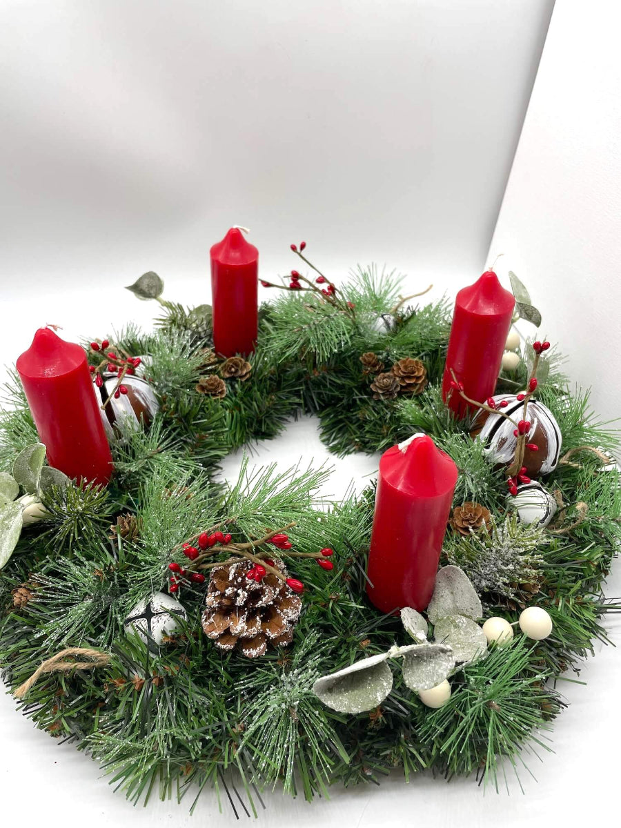 handmade Christmas Advent wreath with red candles and decorative winter elements