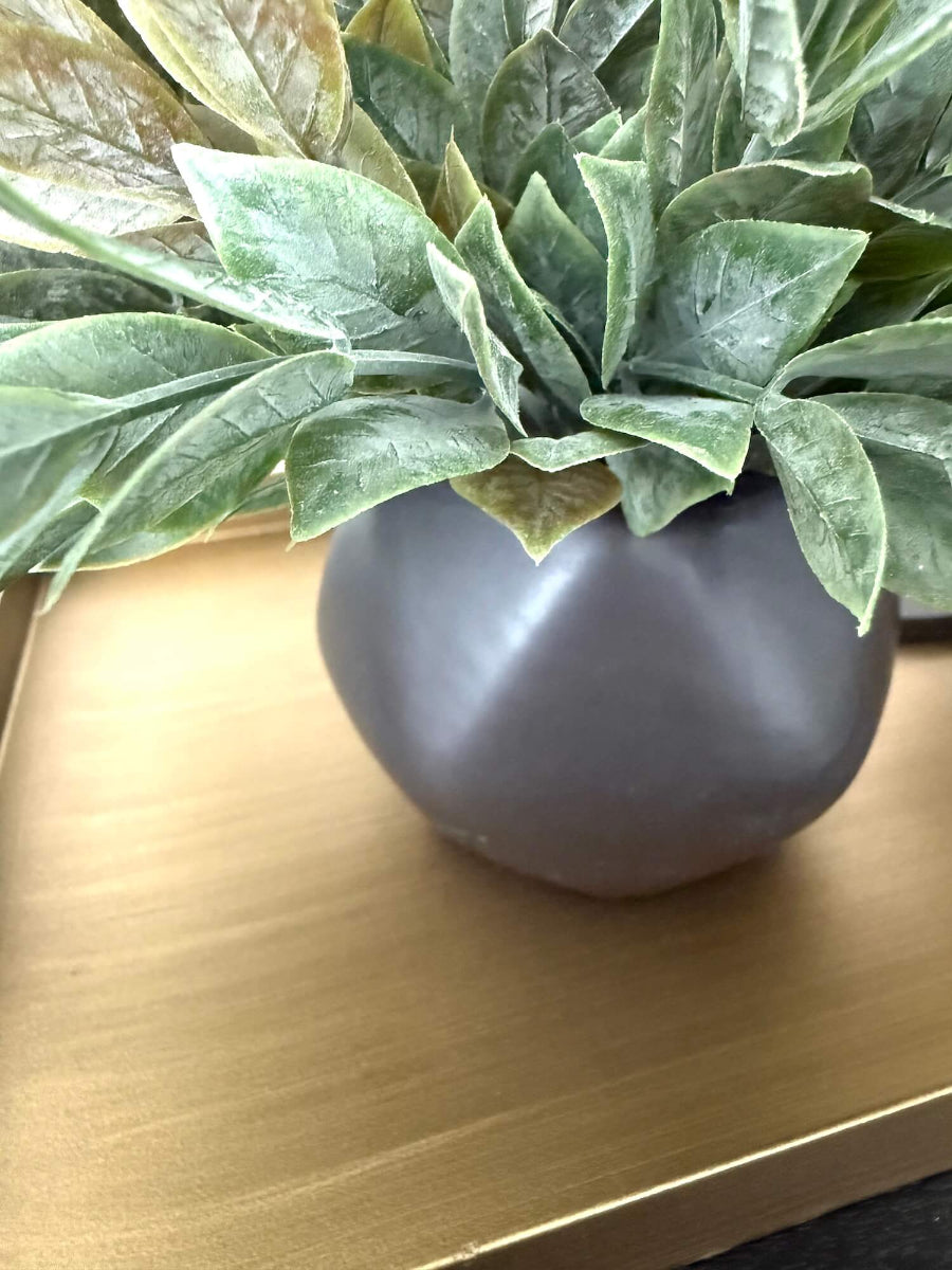 close up fo Dusty green faux plant with lush realistic foliage in a black matte geometric ceramic pot, styled for a shelf, desk, countertop, or small space