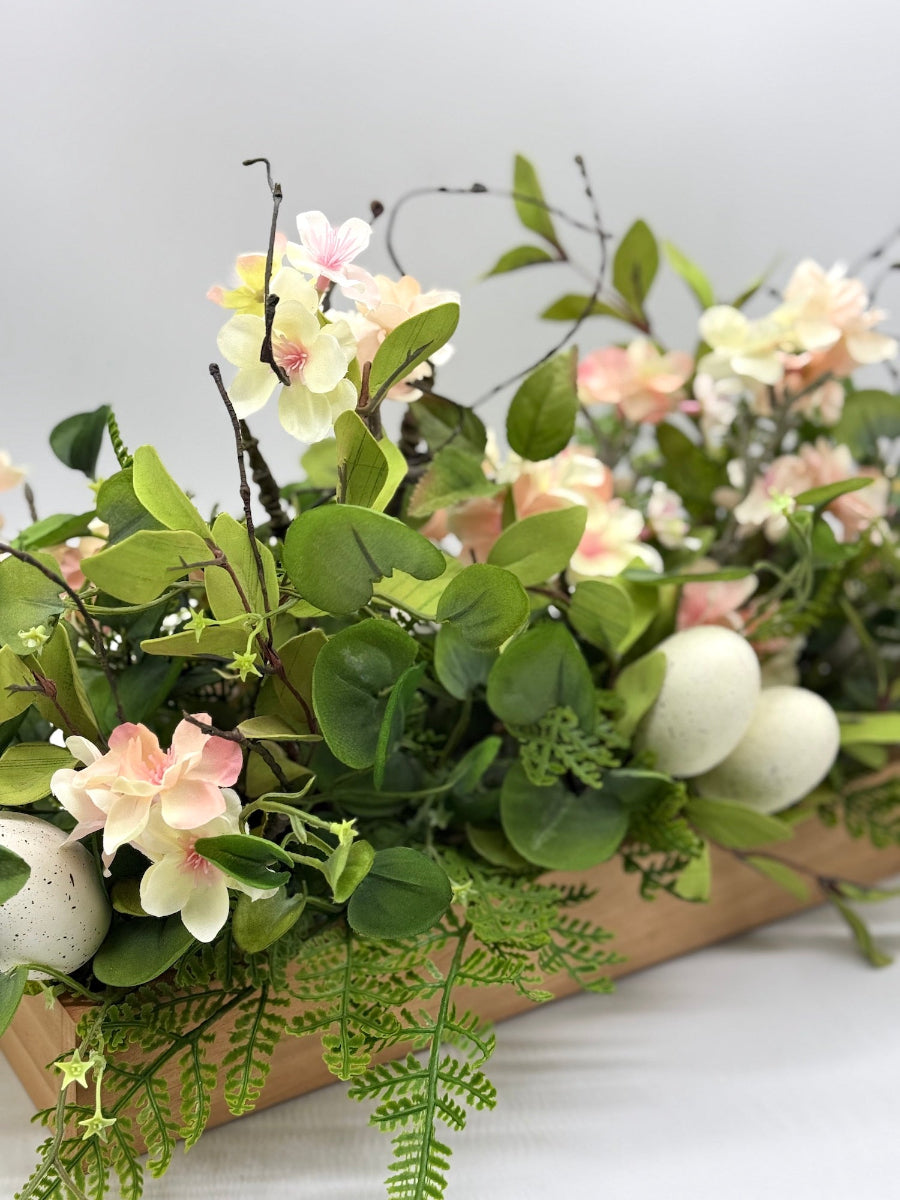 easter arrangement with greenery cherry blossom faux eggs in wooden base