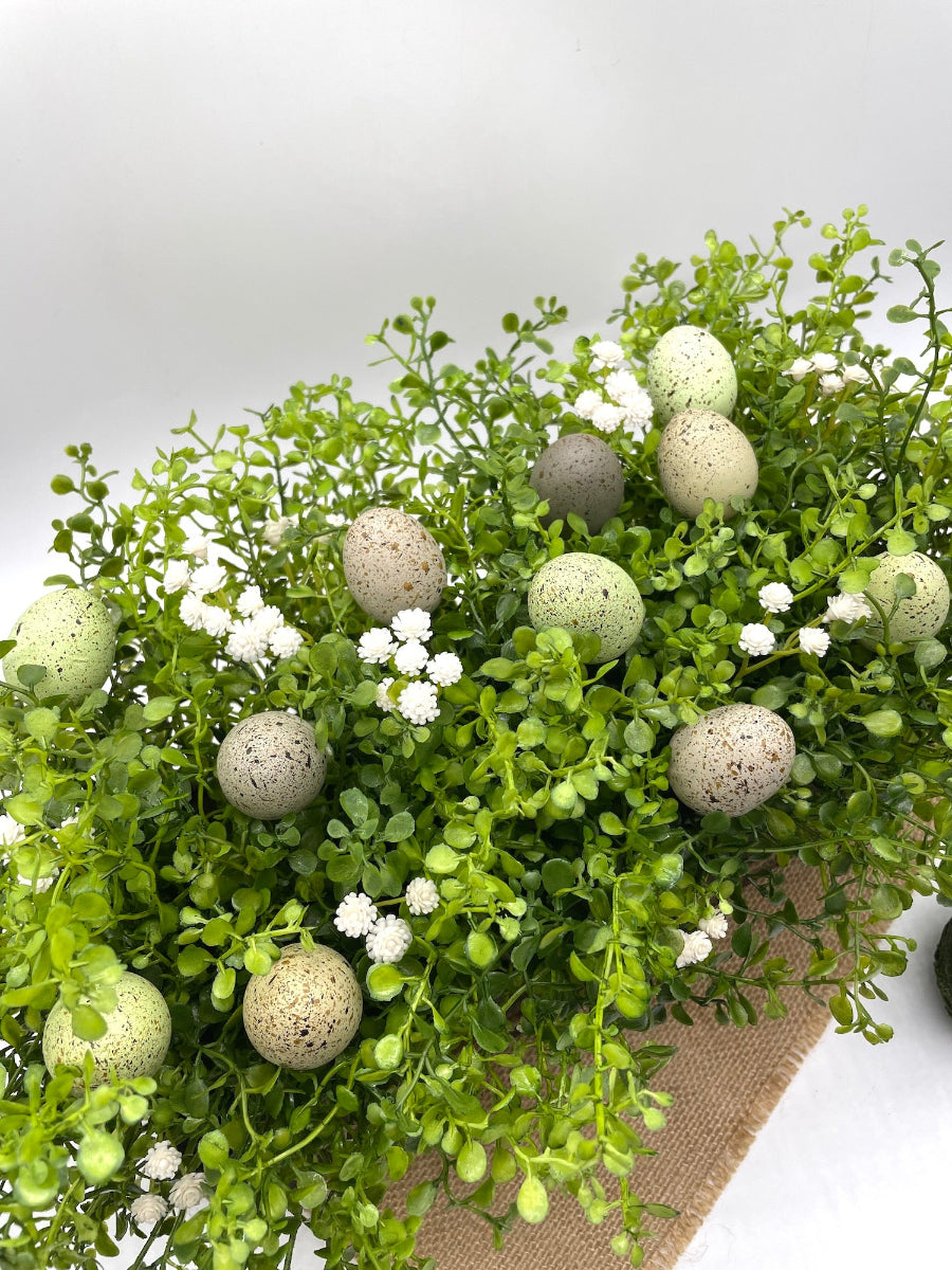 view from top for Greenery Centerpiece with delicate white flowers and small faux eggs for Easter table