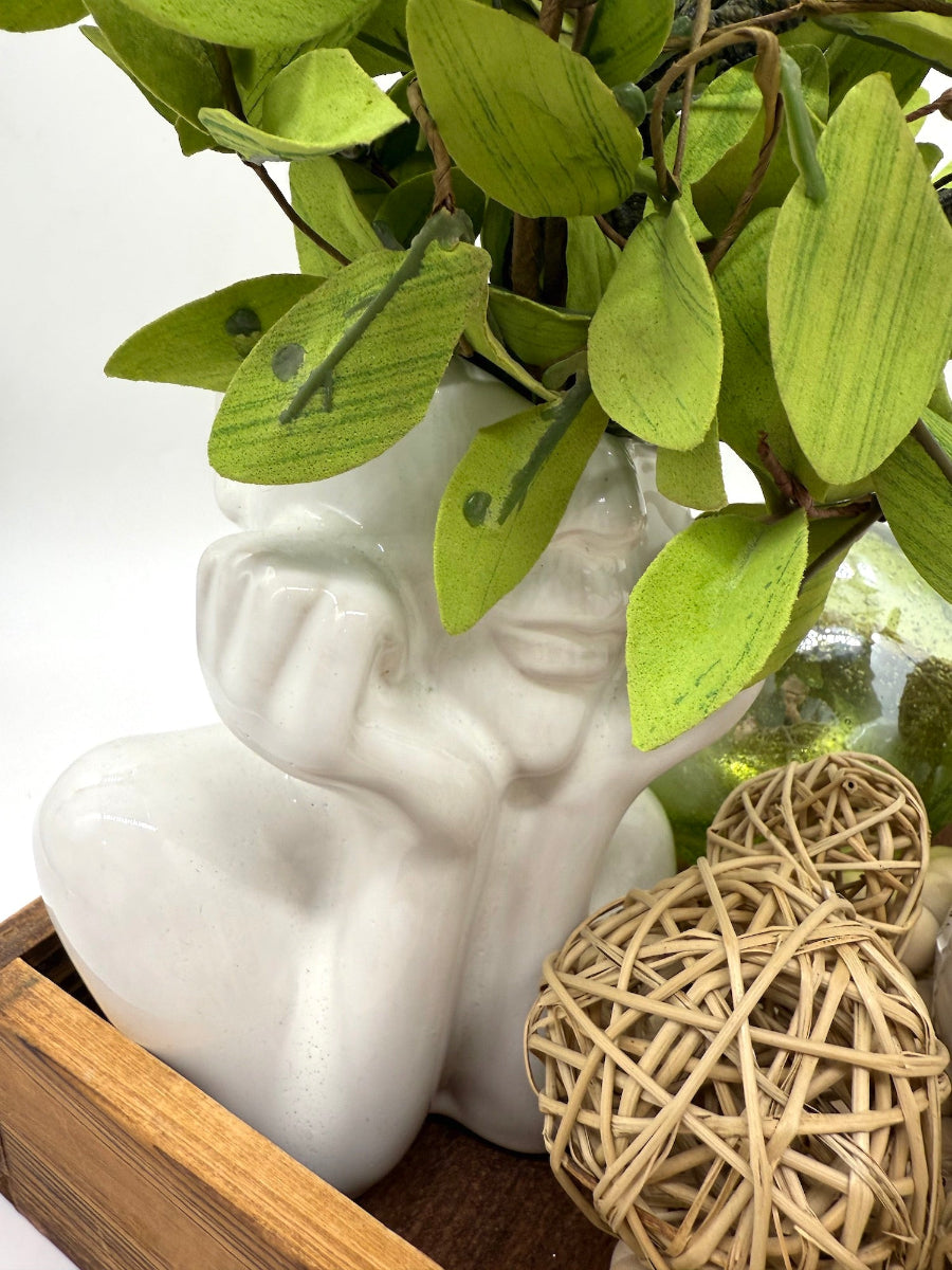 elegant arrangement of artificial plants in ceramic lady head vase