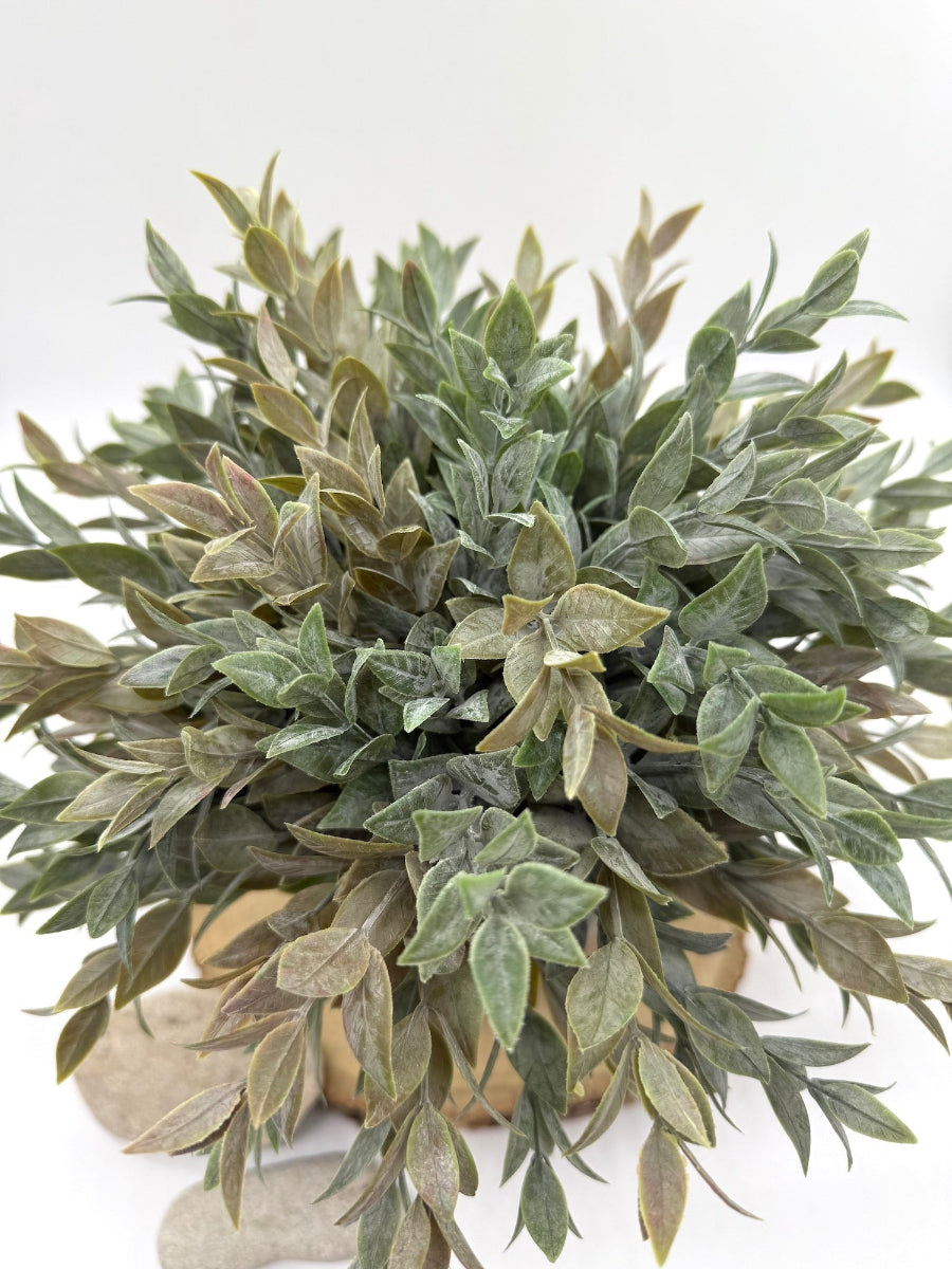 Artificial green plant in a pot on a white background