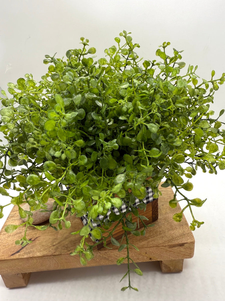 lifelike lush faux greenery in rustic wooden vase with black-white buffalo plaid ribbon