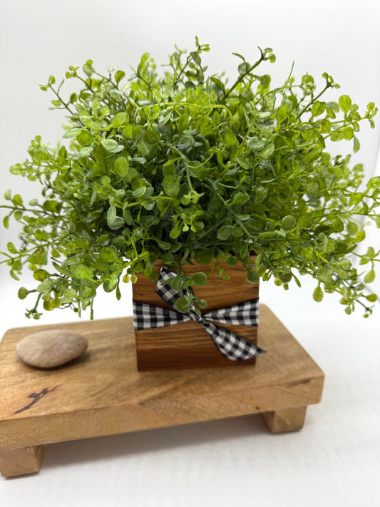 realistic ush faux plant in rustic wooden vase with buffalo plaid ribbon