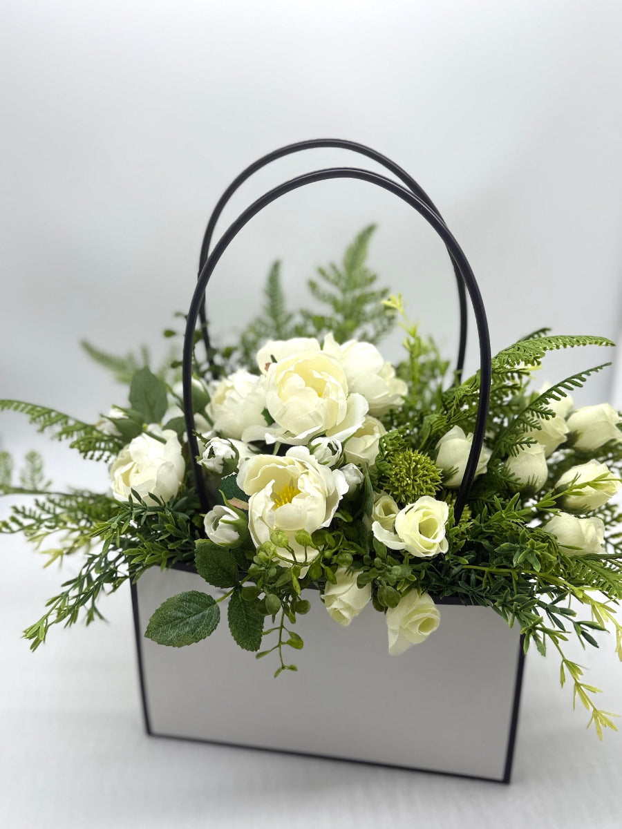 realistic white roses and greenery in white gift bag