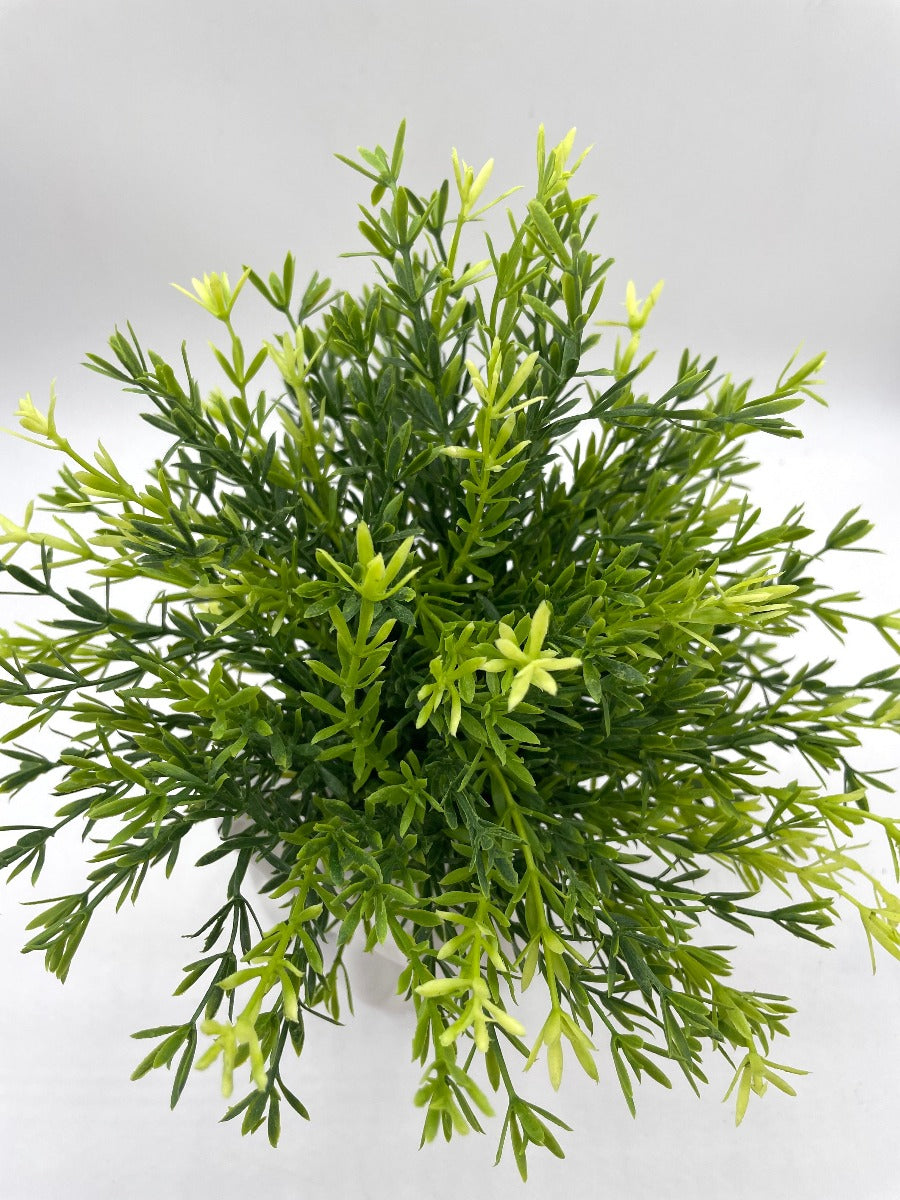 view from top from vivid green realistic looking faux plant in white ceramic woman head vase