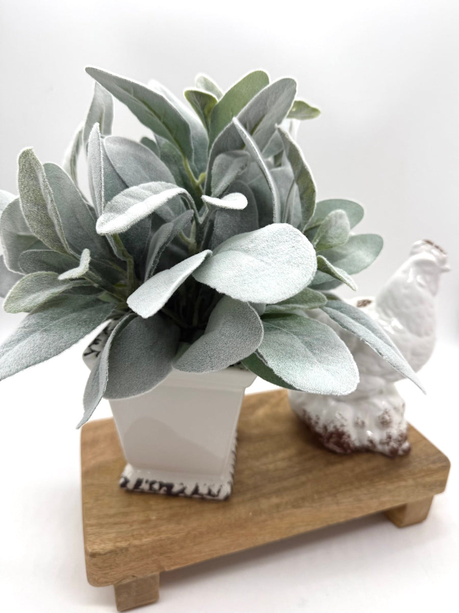 realistic faux lambs ear arrangement in white square ceramic vase