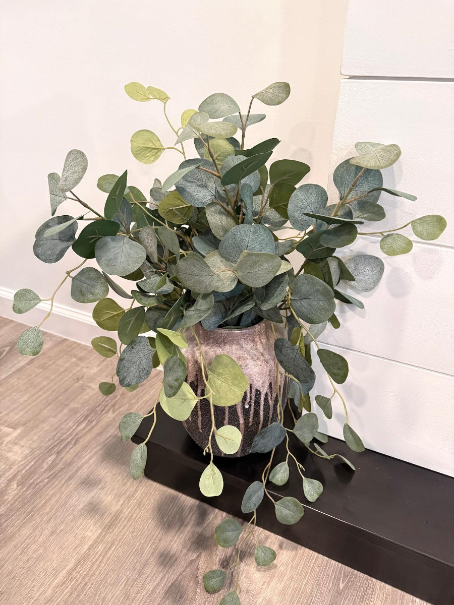 Large realistic looking Faux Silver Dollar Eucalyptus in unique Ceramic Vase styled on fireplace hearth