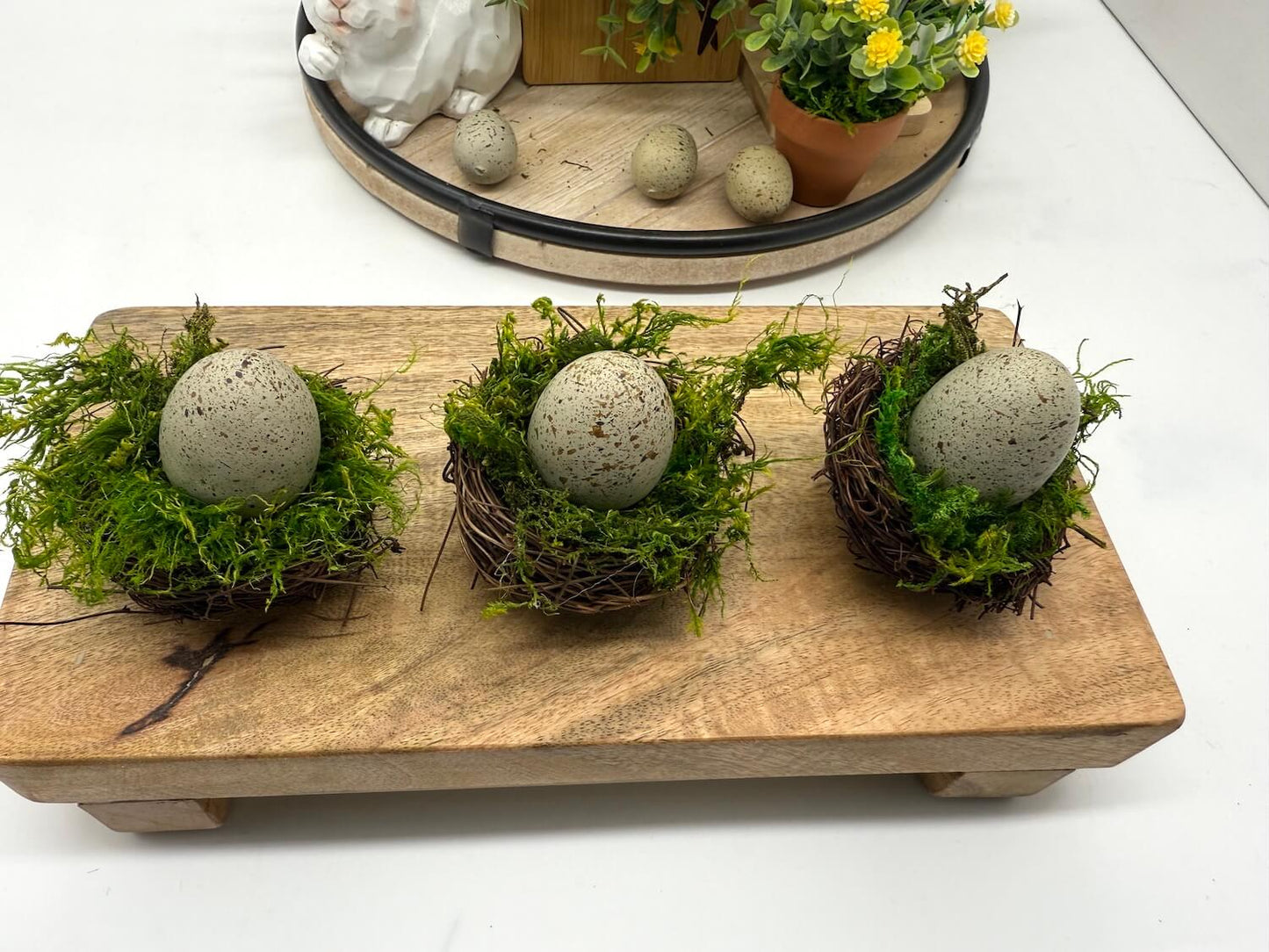 faux egg in gray color in nest filled with moss