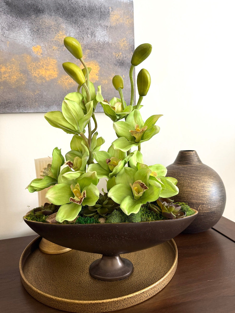realistic green orchid flowers in oval vase with succulents and moss and grapewood