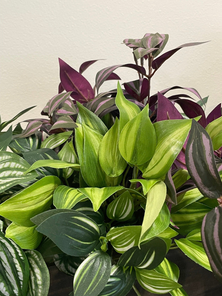 close up of mix of artificial plants with leaves in green, green-white, vivid green, burgundy