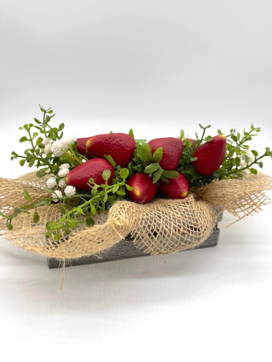 realistic Artificial Strawberry in wooden crate in gray or white decorated with greenery, white flowers and burlap