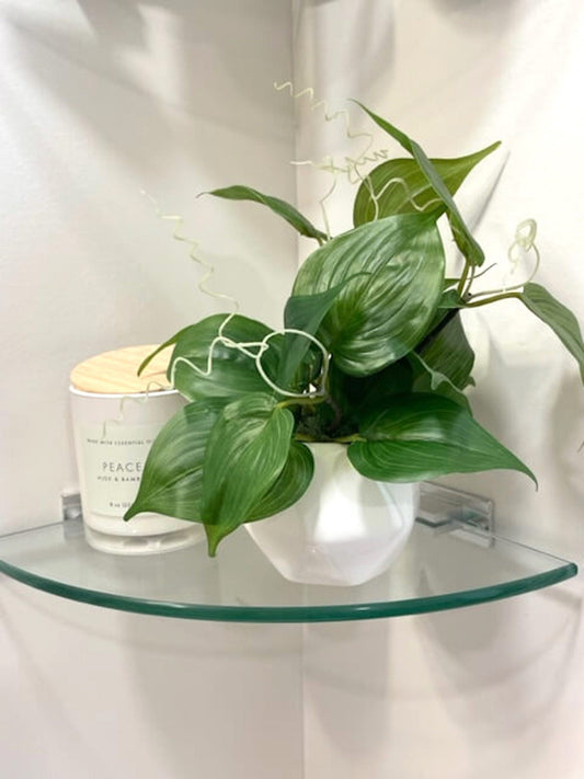 vivid green faux plant is small white ceramic pot