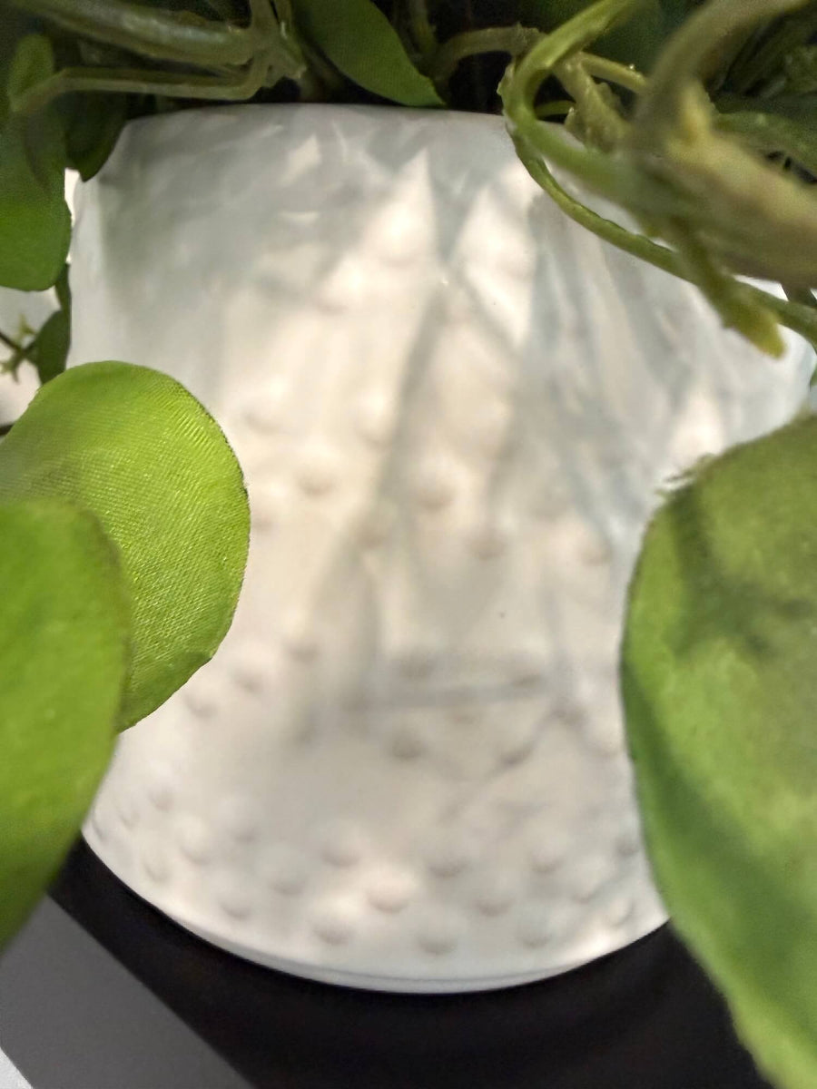 close up for pot of realistic looking faux greenery with fabric leaves in white eramic textured pot