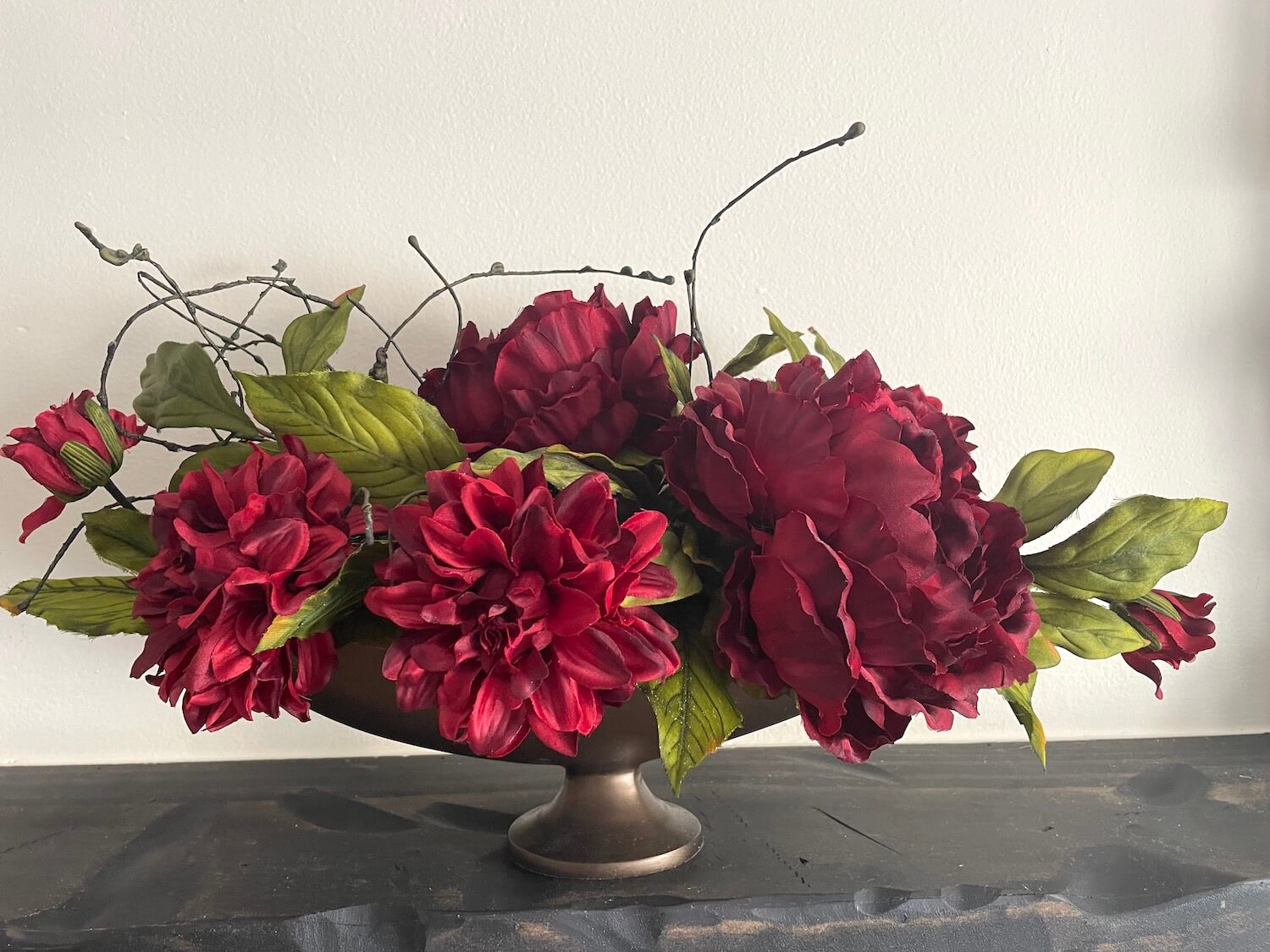 deep red flowers in oval bonze metal vase elegant centerpiece