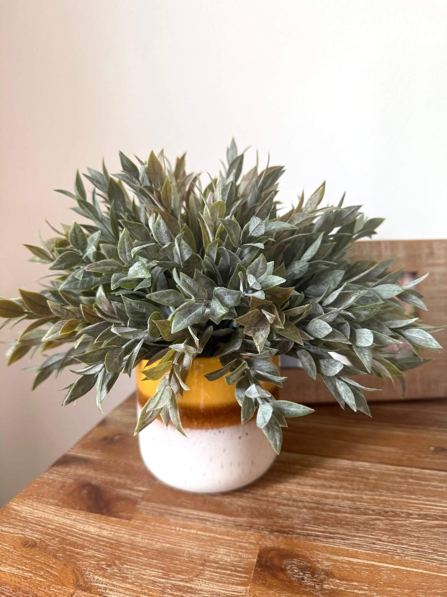 muted dusty green faux plant in yellow ceramic vase for table and shelf