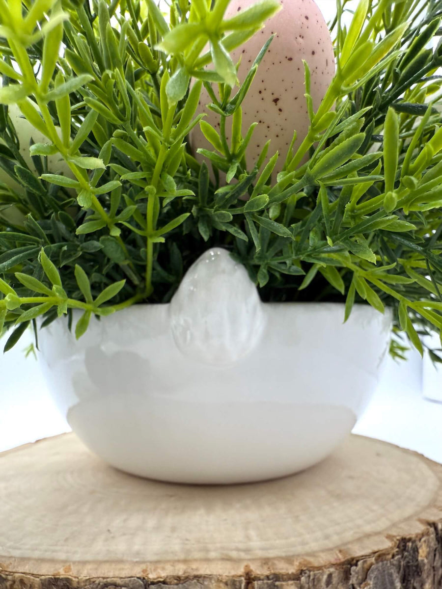 back of bunny ceramic white vase filled with greenery and faux eggs