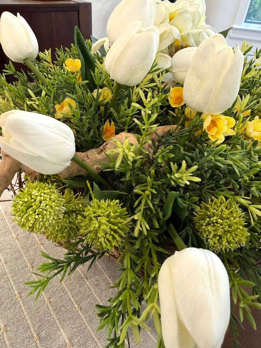 close up for white tulips, yellow flowers and greenery in easter centerpiece