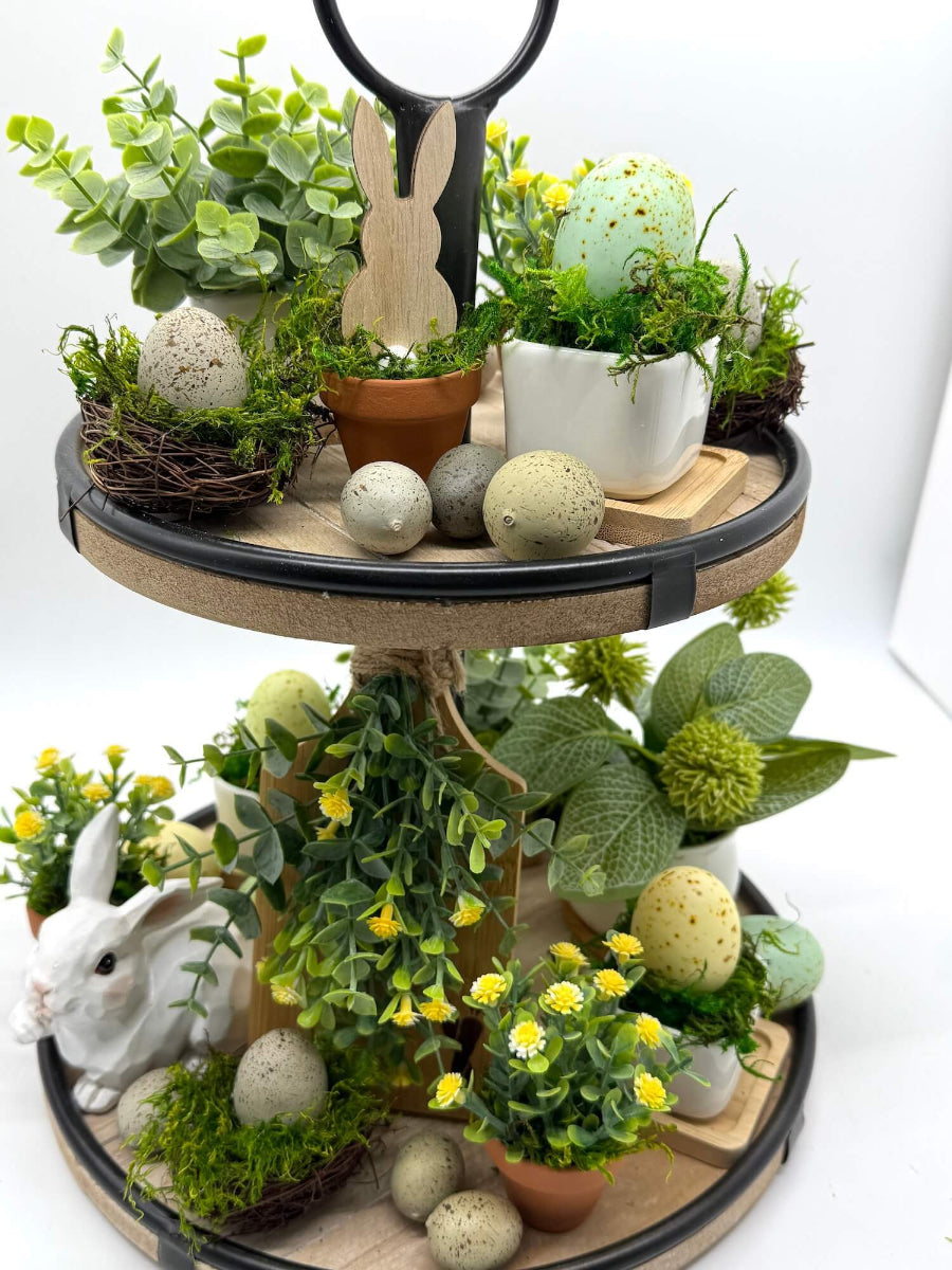faux egg on nest filled with moss displayed on decorative easter tiered tray