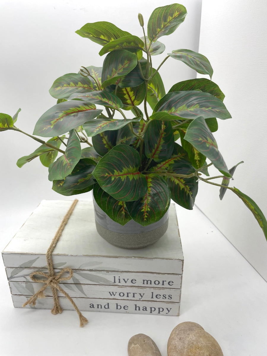 realistic lush faux plant with geen leaves in gray ceramic pot