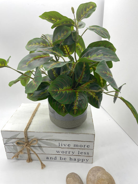 realistic lush faux plant with geen leaves in gray ceramic pot