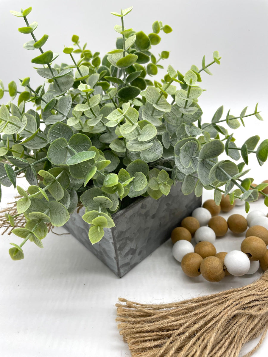 back view of Faux eucalyptus plant in a metal pot drawer decorated with burlap