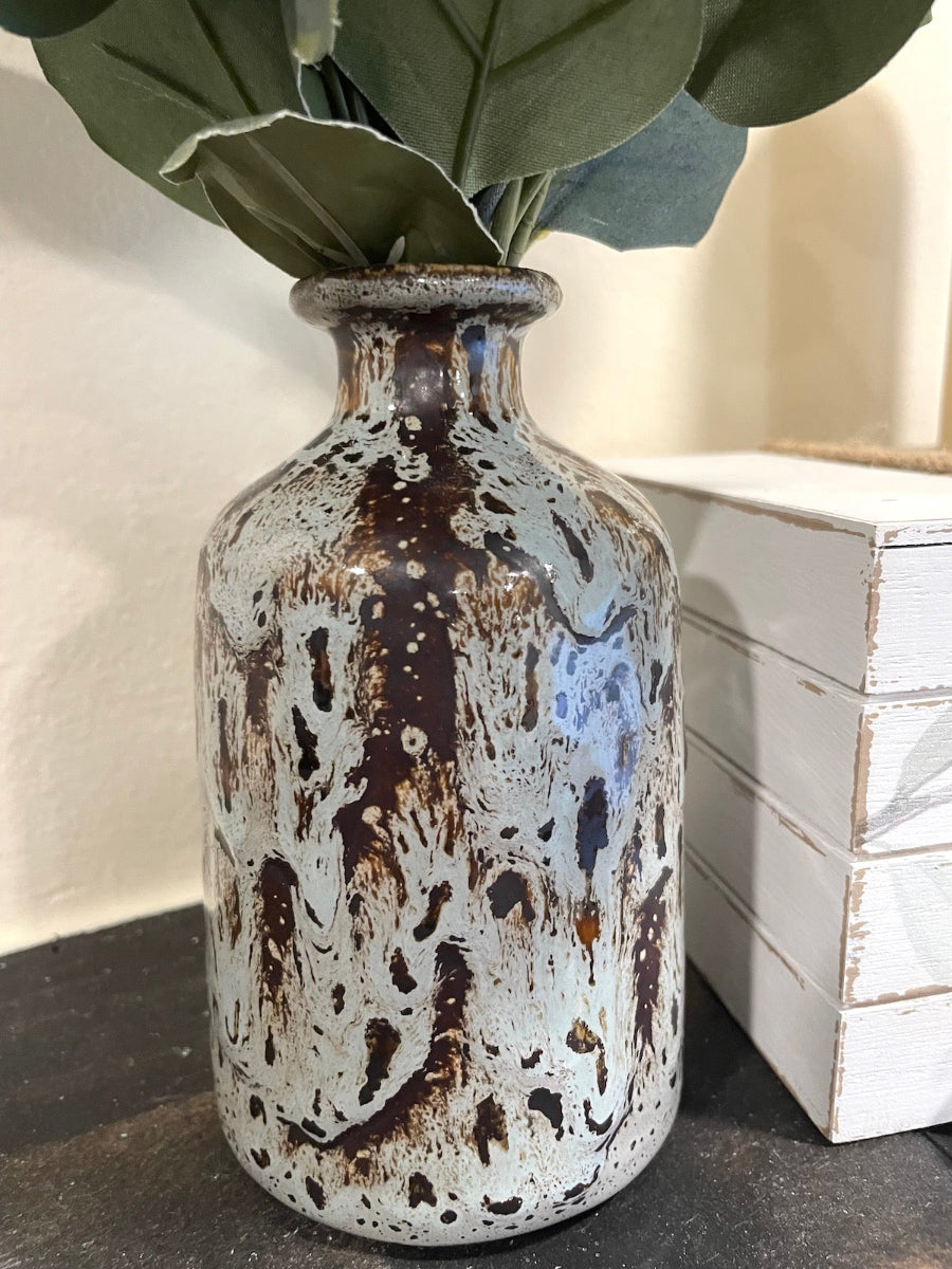close up of Silver Dollar Eucalyptus Stems in ceramic Vase in gray and brown
