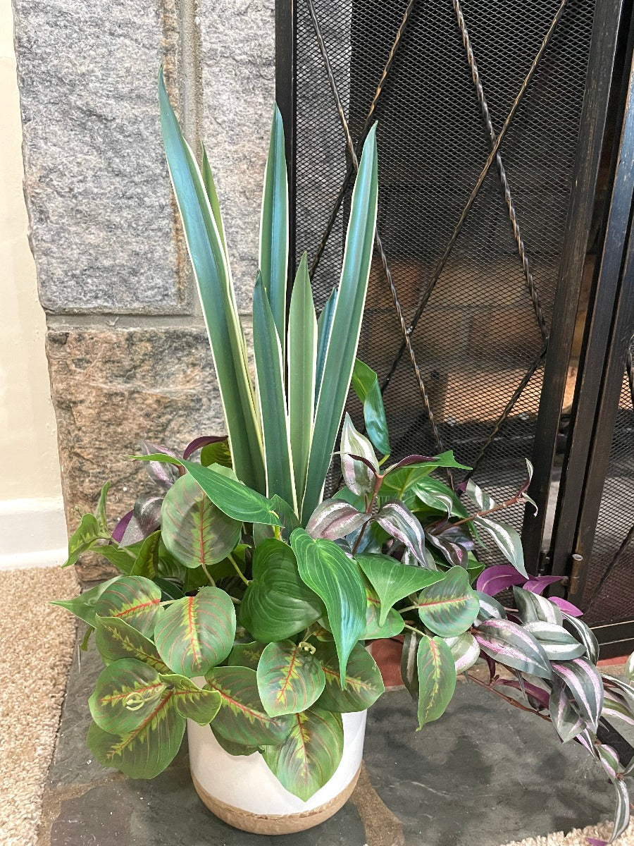 realistic looking faux plant arrangement created from 4 plants, set in large white ceramic pot, from tall green to dripping burgundy