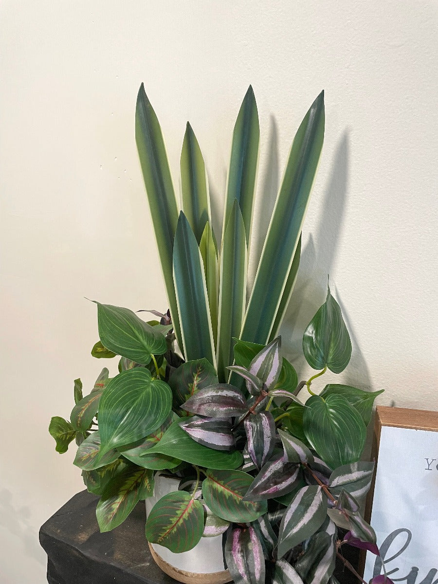 realistic looking faux plant arrangement created from 4 plants, set in large white ceramic pot, from tall green to dripping burgundy