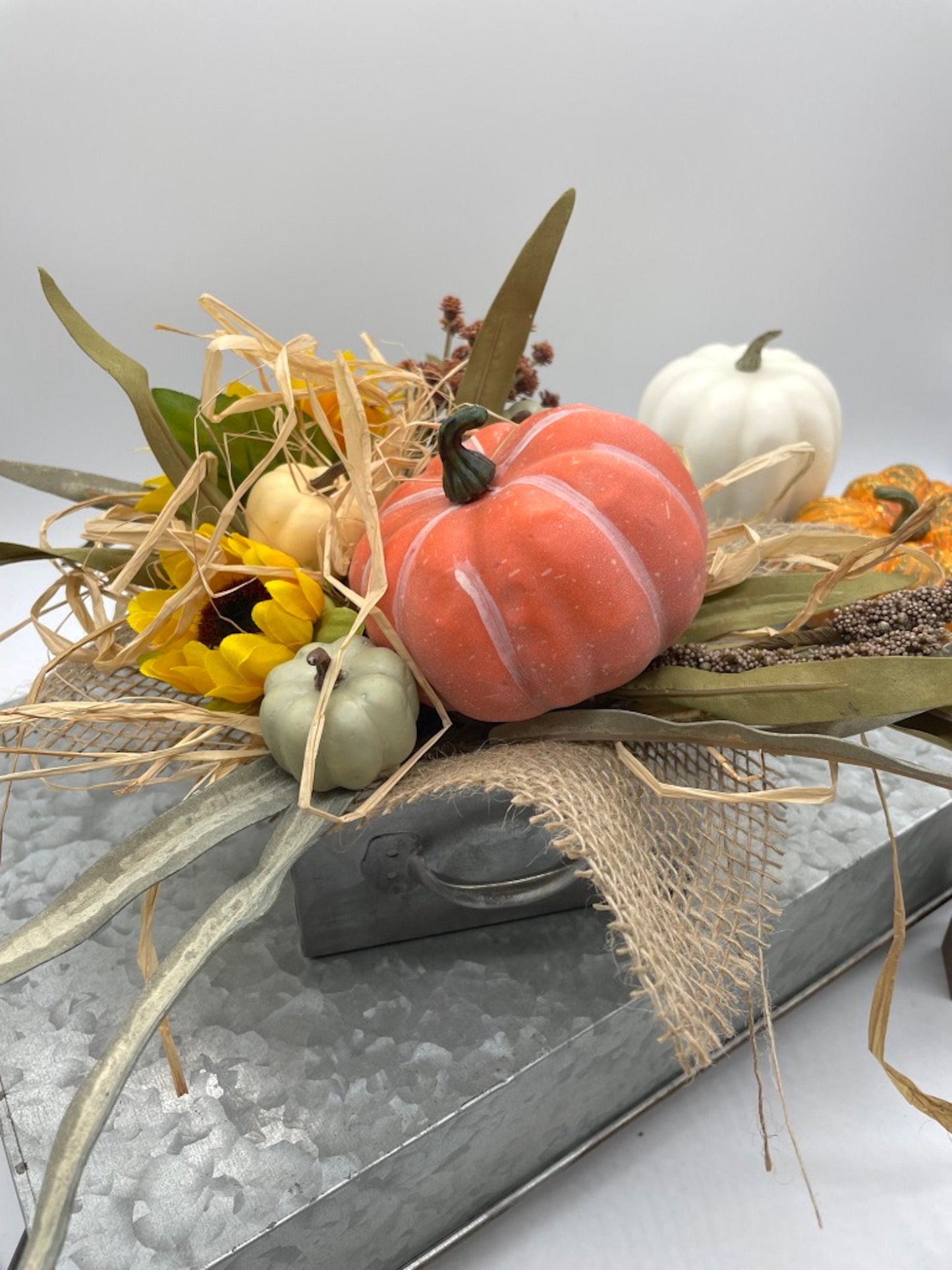 fall centerpiece with faux pumpkin, flowers and wheat stems in metal vase drawer shape