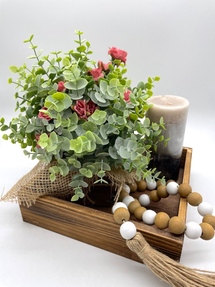 Farmhouse Tray Decor with faux eucalyptus arrangement, wooden bead garland and candle on wooden square tray