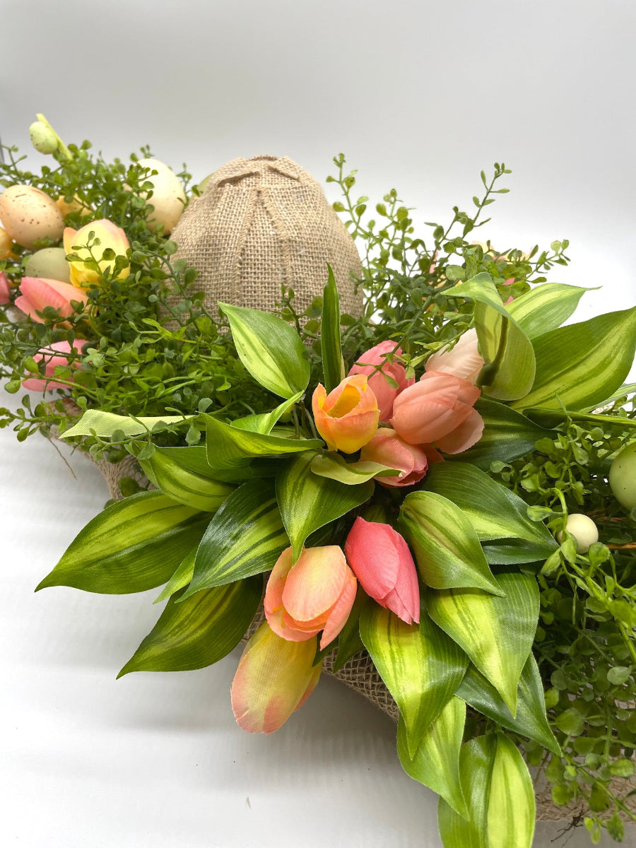 fake colorful tulips, faux eggs and variety of greenery in wooden planter