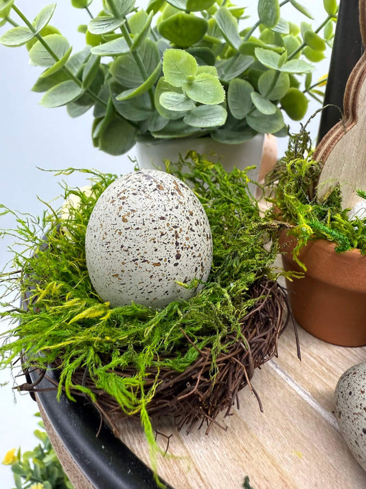 gray faux eggs on a nest filled with moss