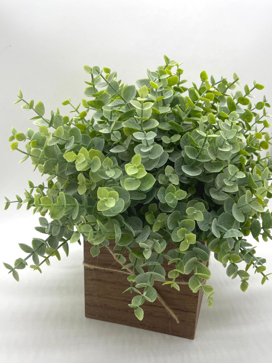 realistic faux eucalyptus arrangement in wooden box vase decorated with jute