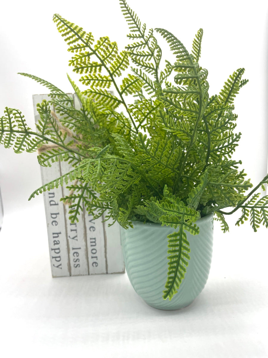 realistic looking faux fern arrangement in textured bluish ceramic vase pot
