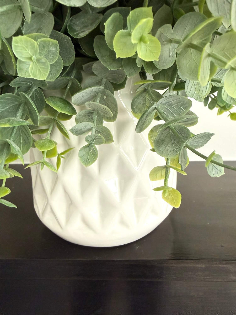 realistic faux eucalyptus plant in white ceramic pot vase of diamond pattern