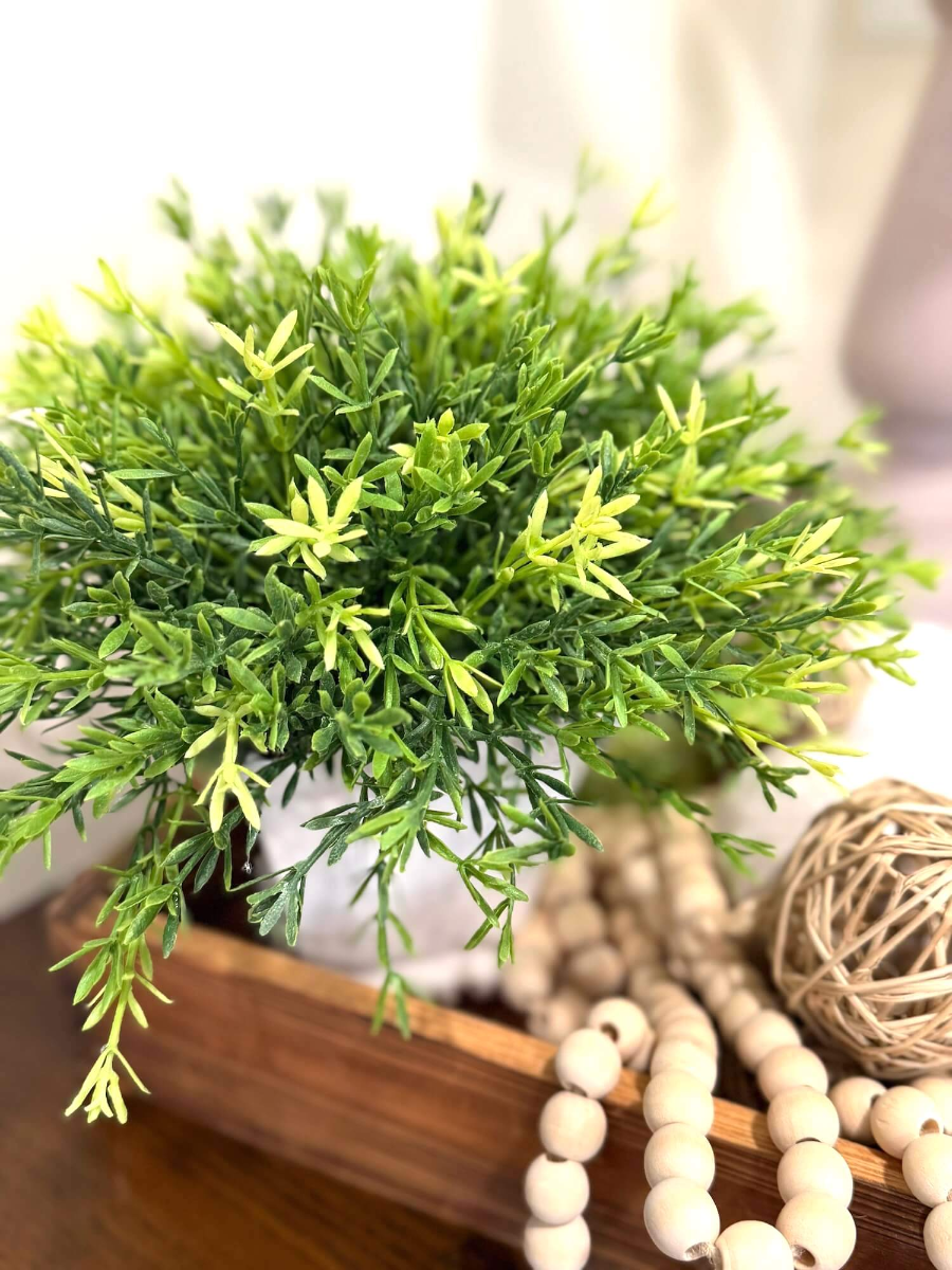 realistic looking vivid green faux plant in white square ceramic vase