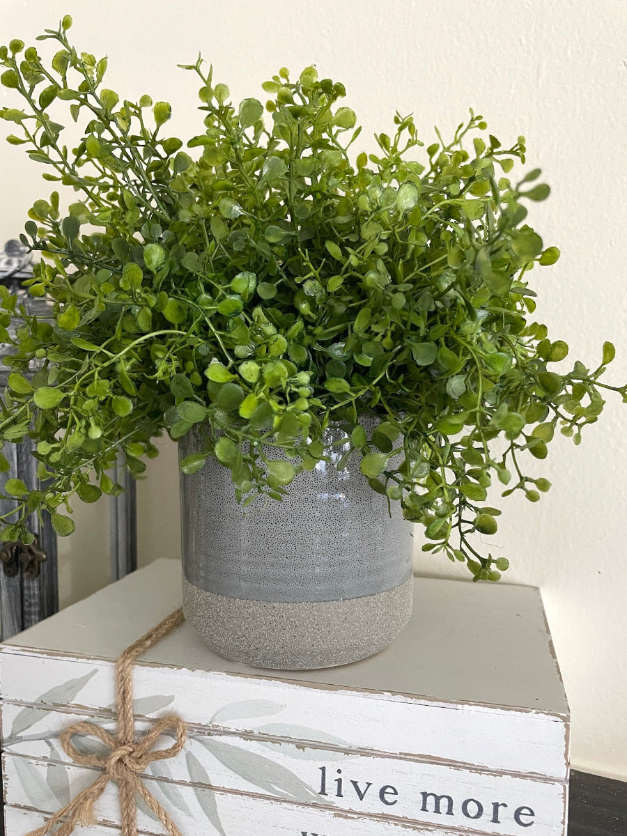 realistic looking vivid green faux plant in gray ceramic vase pot