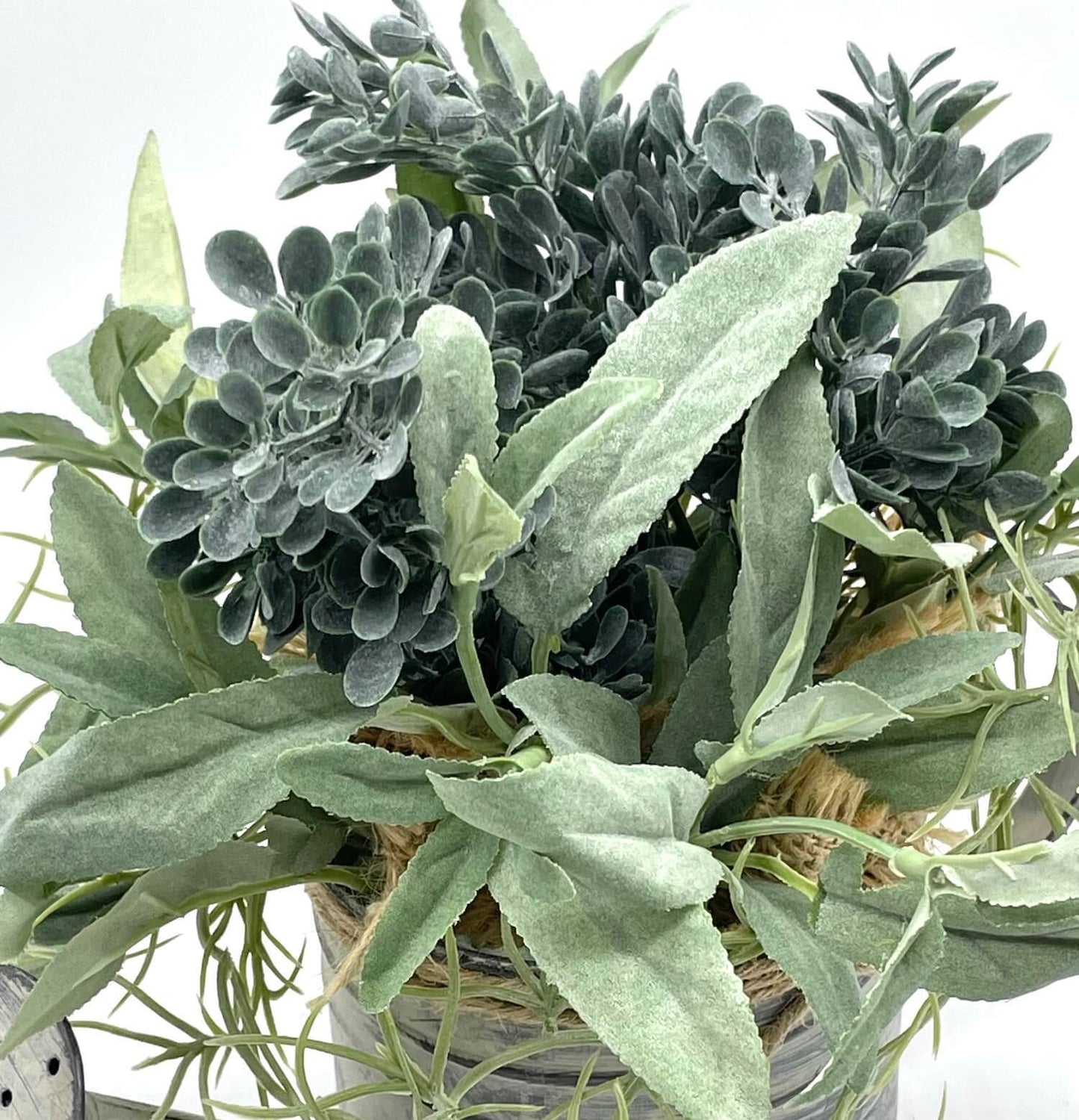 close up for realistic Greenery Arrangement with 3 types of plants in dusty green in Metal Watering Can decorated with burlap and jute