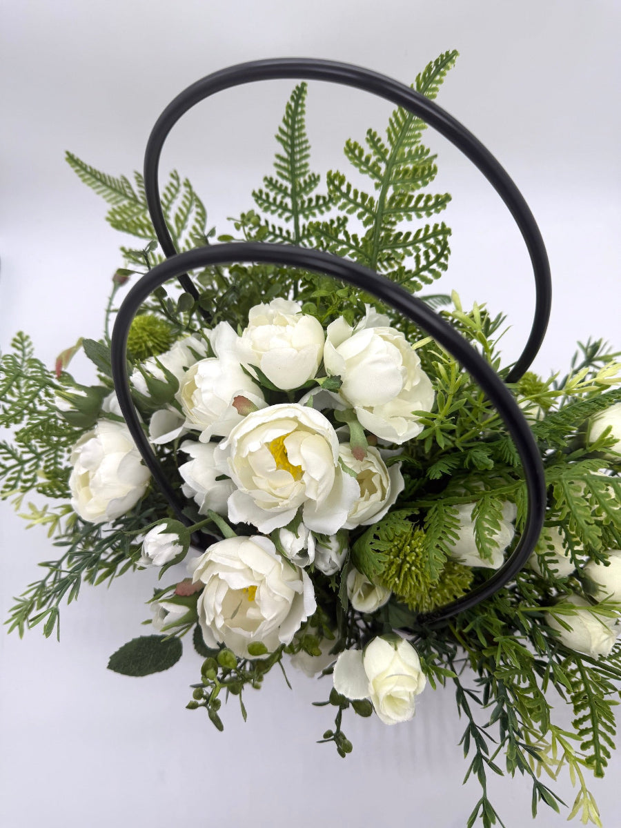bouquet of white roses and greenery in white gift bag with handles