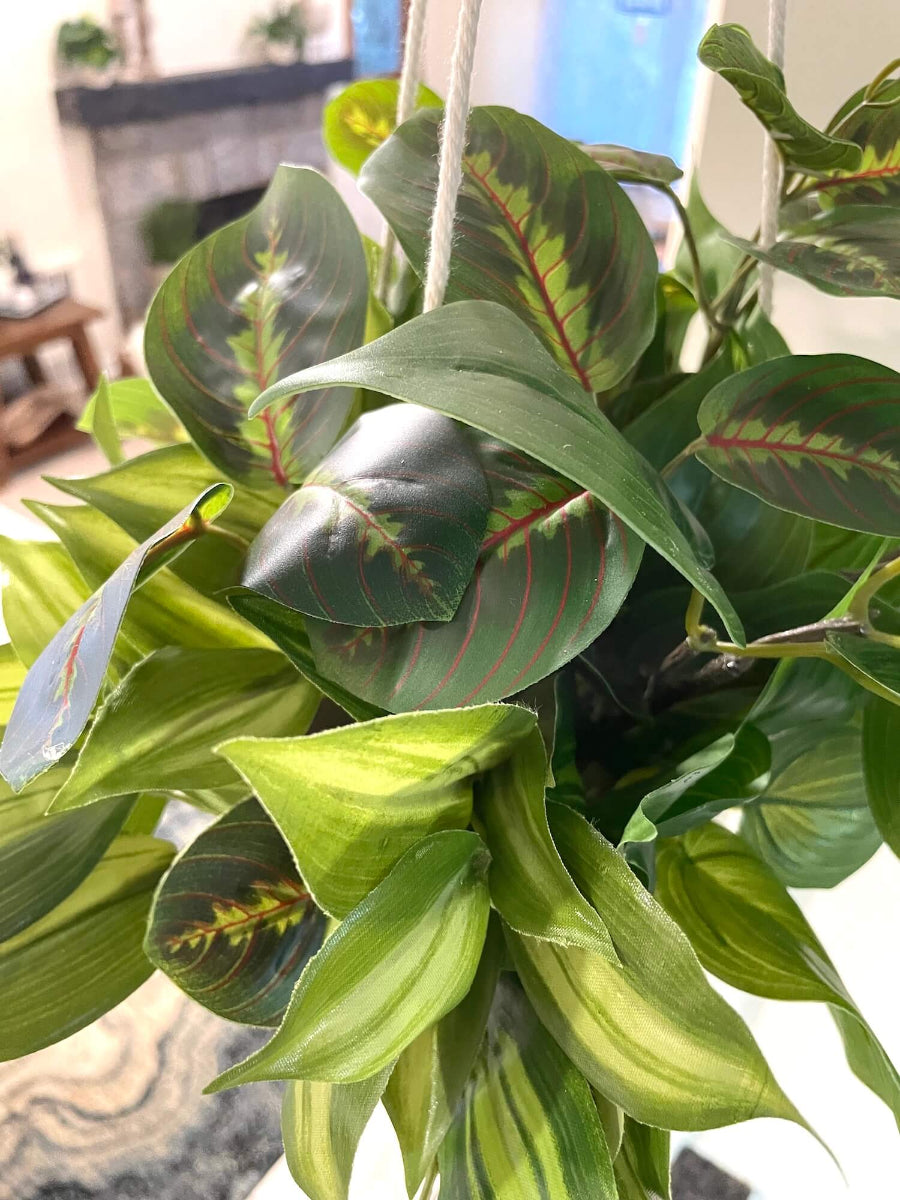 mix of faux plants of variety of green shades and shape in white ceramic hanging pot