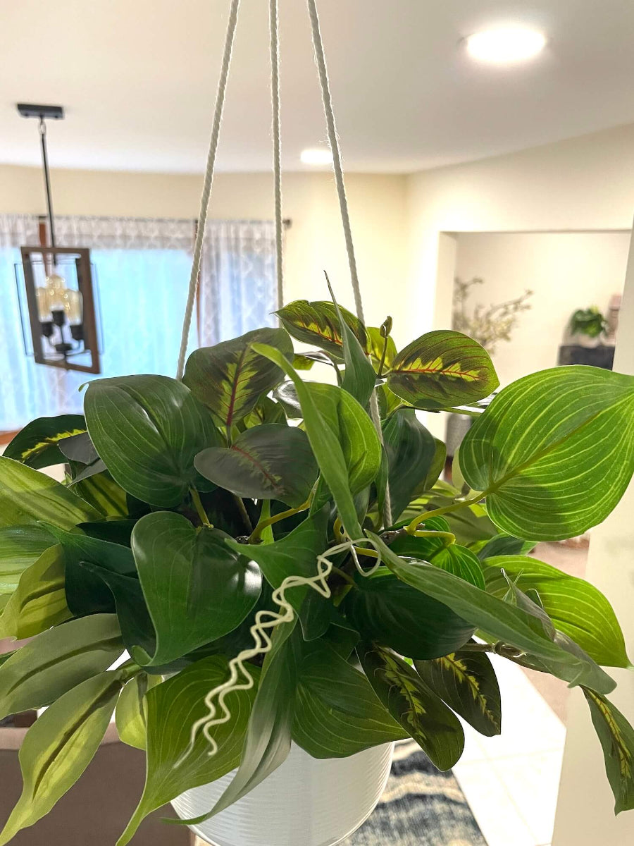 mix of faux plants of variety of green shades and shape in white ceramic hanging pot