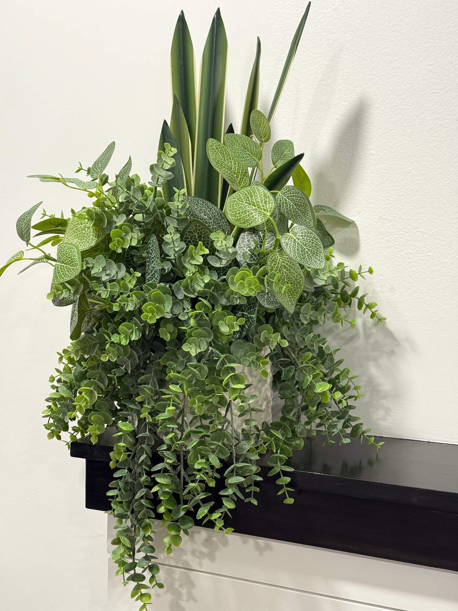 Artificial green plant arrangement of three types of plants in white ceramic pot