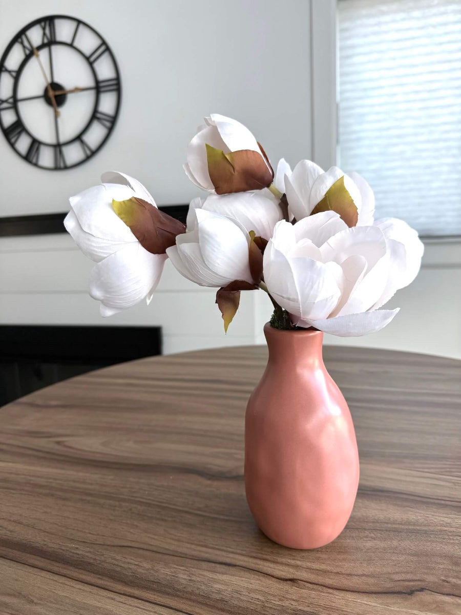 white magnolia arrangement in ceramic vase in clay color