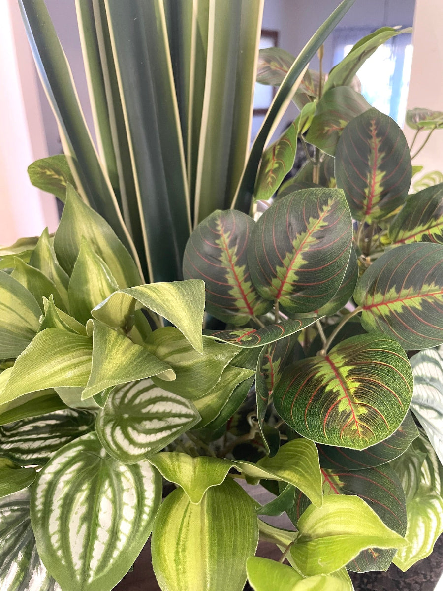 close up for mix of tall and lush faux plants of variety of green colors and white accents in wooden planter stained is expresso color