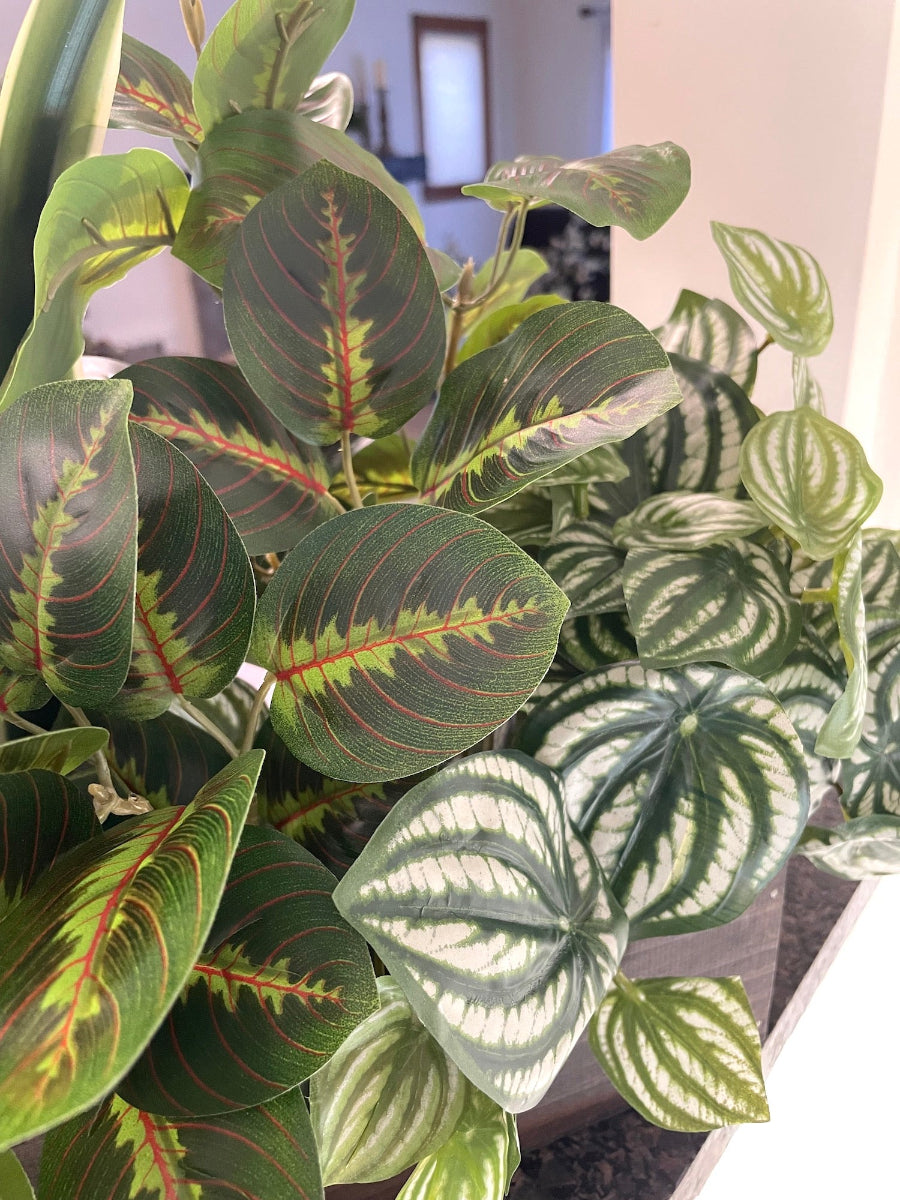 close up for mix of tall and lush faux plants of variety of green colors and white accents in wooden planter stained is expresso color