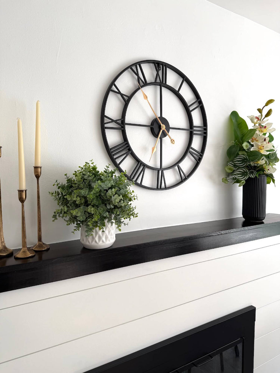 realistic looking elegant white orchid arrangement with greenery and decorative foliage in black textured ceramic vase