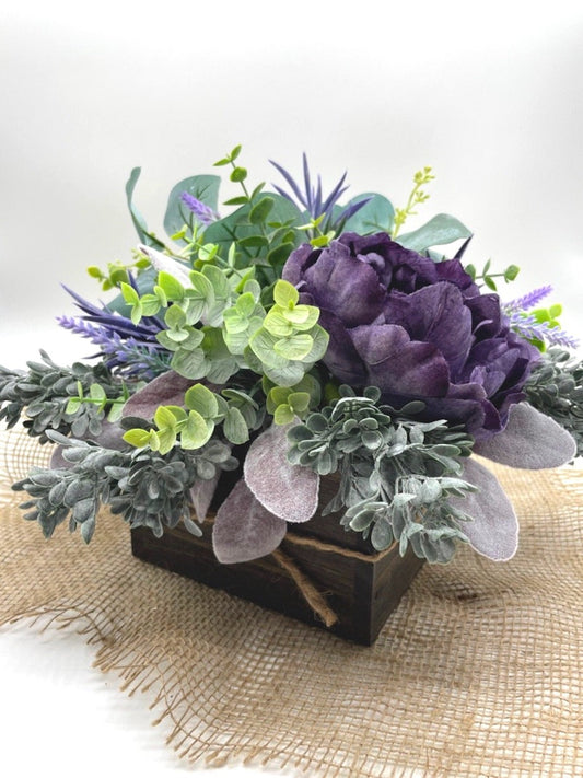 Purple Floral Arrangement with variety of greenery from green to purple in wooden square planter stained with expresso color