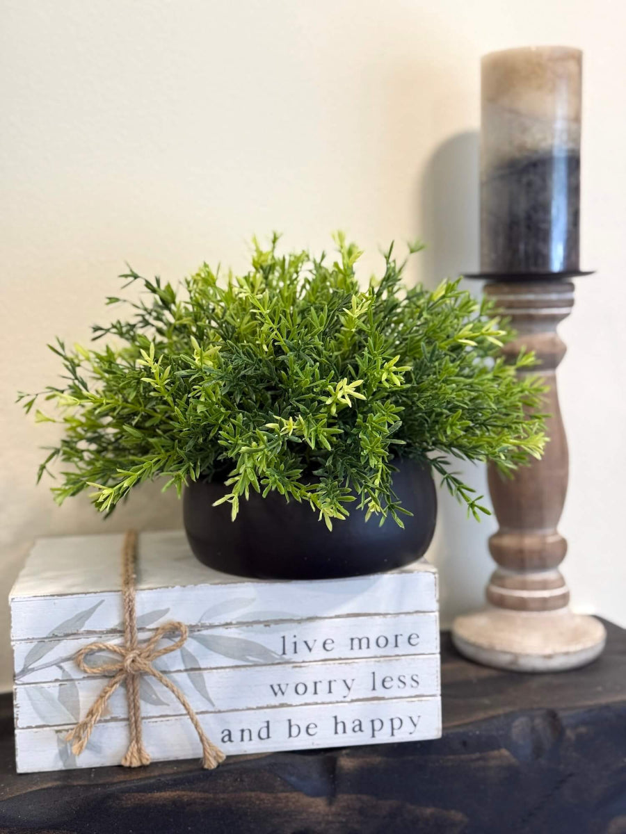 realistic green faux plant in black low ceramic pot