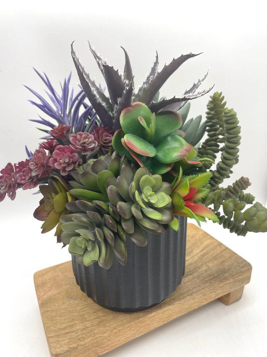 Faux Succulent Centerpiece-mix f variety of succulents in different shapes and style  in variety of green to burgundy and purple, all set in textured black ceramic pot vase
